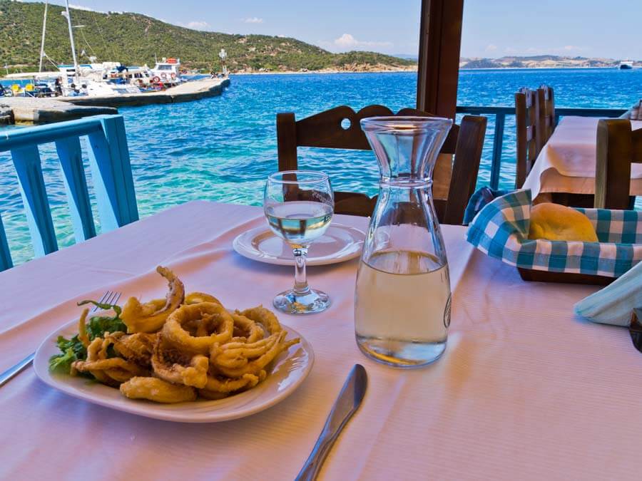 Seaside taverna with fried squid and wine on the table
